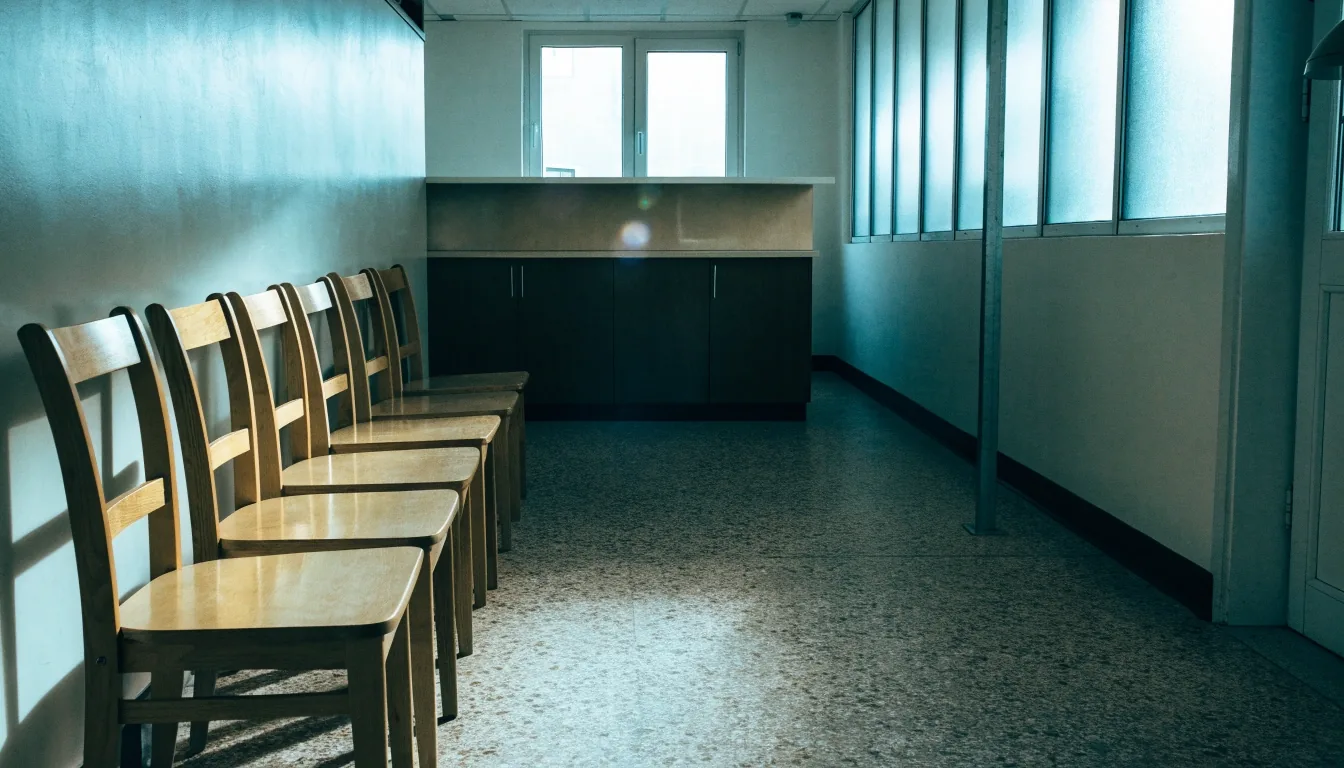 Pasillo vacío de un edificio institucional español con luz fría de mediodía